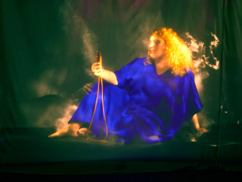 A person wearing a blue dress is sitting on the floor.